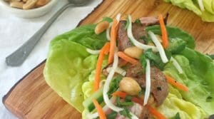 Pork and peanut lettuce wraps on a wooden board
