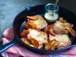 Pork chops in a cast iron skillet with apples
