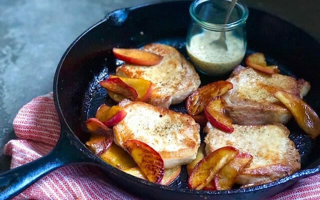 Pork chops in a cast iron skillet with apples