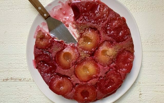 upside down plum cake with a spatula