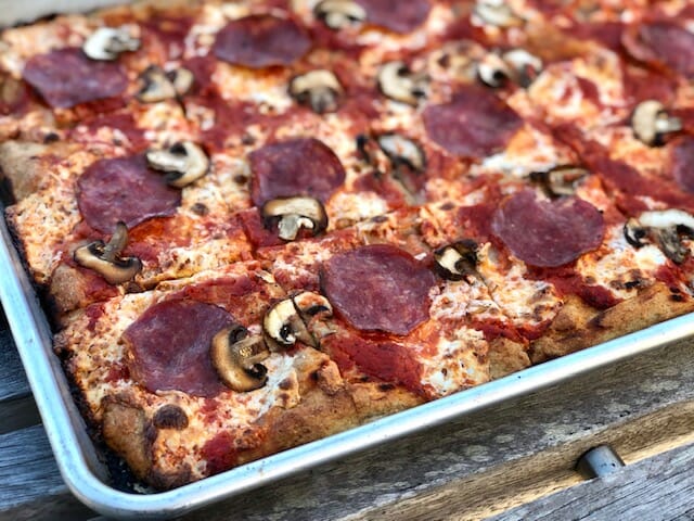 Close of of No-Knead Sheet Pan Pizza topped with salami and mushrooms