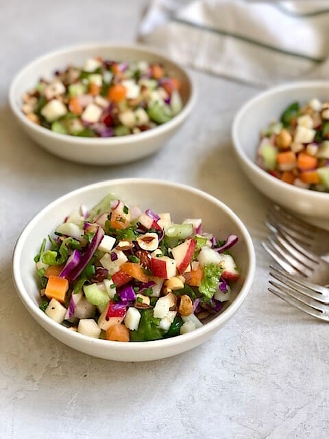 Flexible Chopped Winter Salad in white bowls with forks