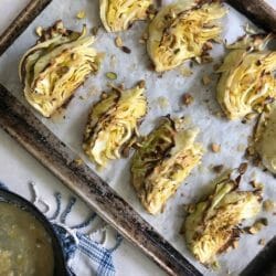roasted wedges of cabbage on a sheet pan with pistachios