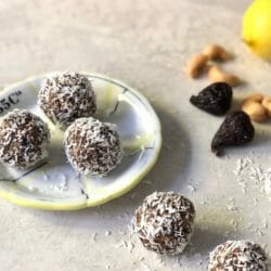 Coconut Fig Energy Balls on a small plate with cashew, lemon and whole figs