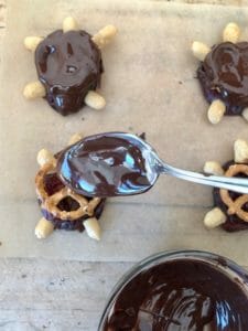 Spoonful of melted chocolate over date chocolate turtle candy