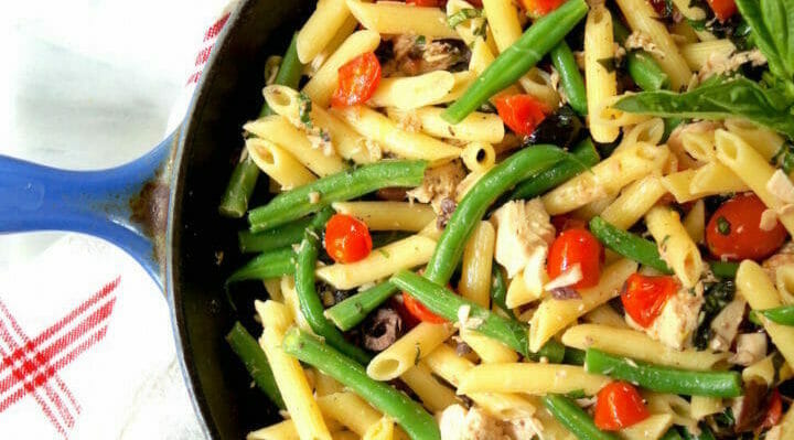 pasta in a cast iron skillet with tuna nicoise ingredients