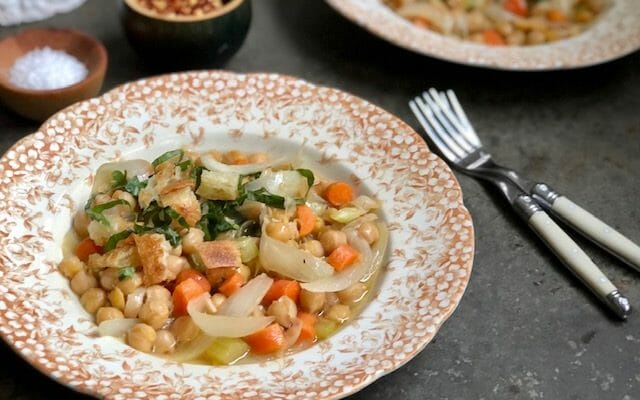 two bowls of chickpeas with garlic olive oil croutons and forks