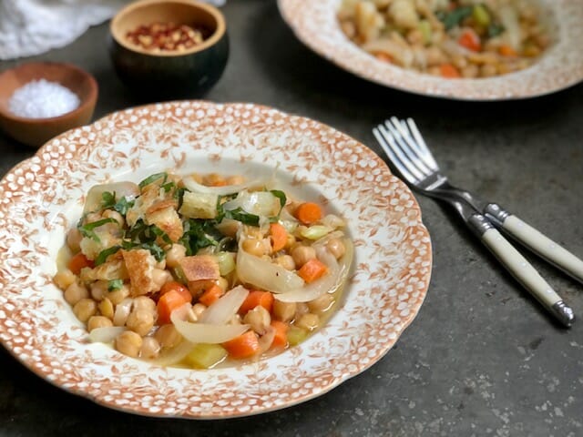 two bowls of chickpeas with garlic olive oil croutons and forks