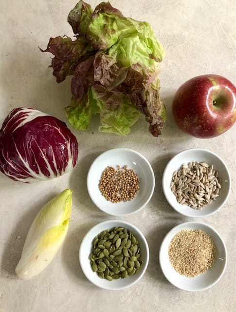 Ingredients for super seed salad: lettuce, seeds, apple