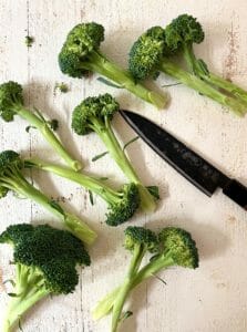 Raw broccoli and knife on a board