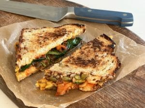 Kimchi grilled cheese on a cutting board with knife