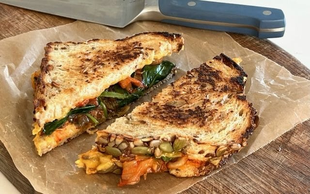 Kimchi grilled cheese on a cutting board with knife