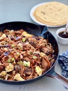 Skillet of moo shu vegetables with tortillas and sauce