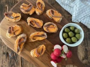 wooden board with anchovy toasts with calabrian chili butter