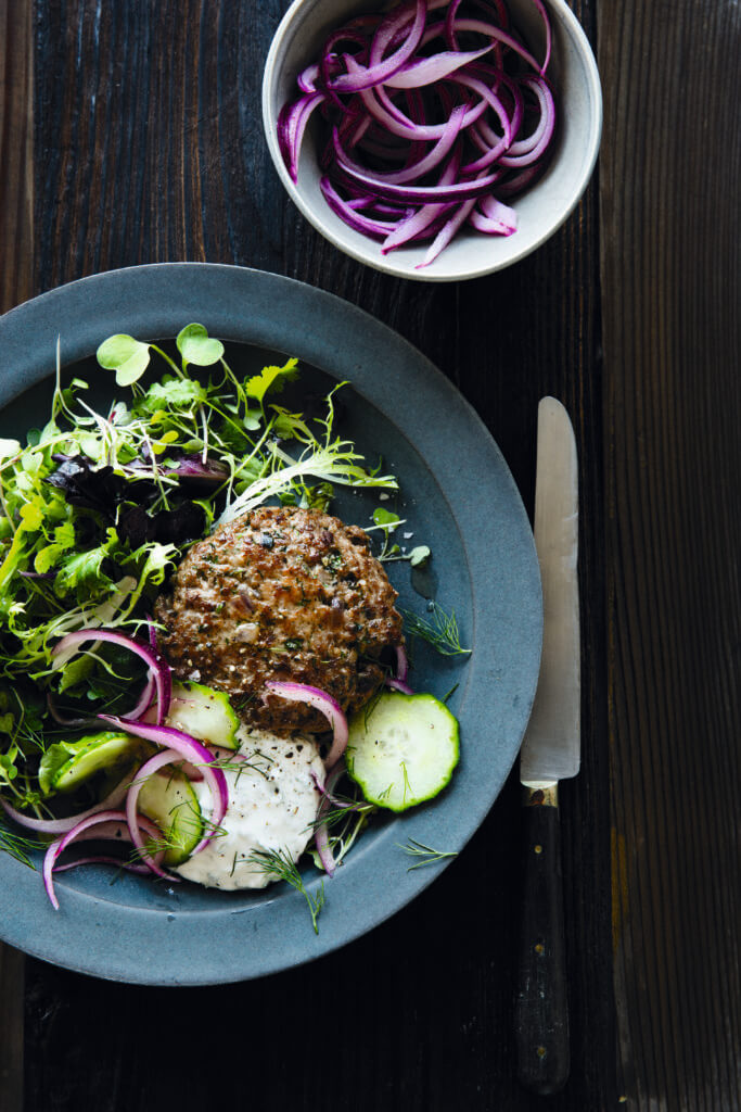 Lamb sliders on a plate with salad and pickled onions