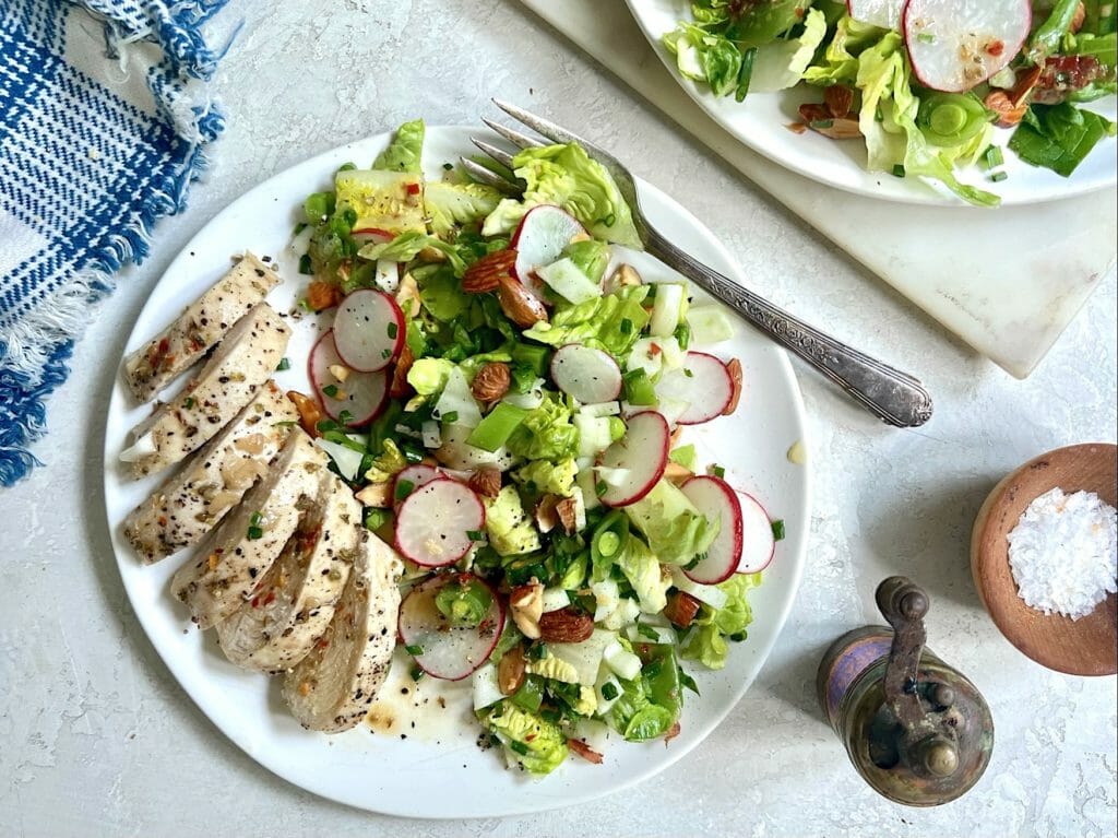 chopped salad with chicken on white plates with blue gingham napkin