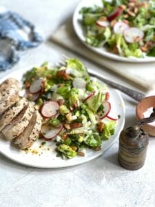 Chopped Salad with chicken on white plates with blue napkin