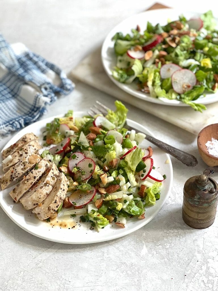 two plates of chopped salad with chicken