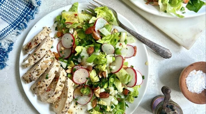 chopped salad with chicken on white plates with blue gingham napkin