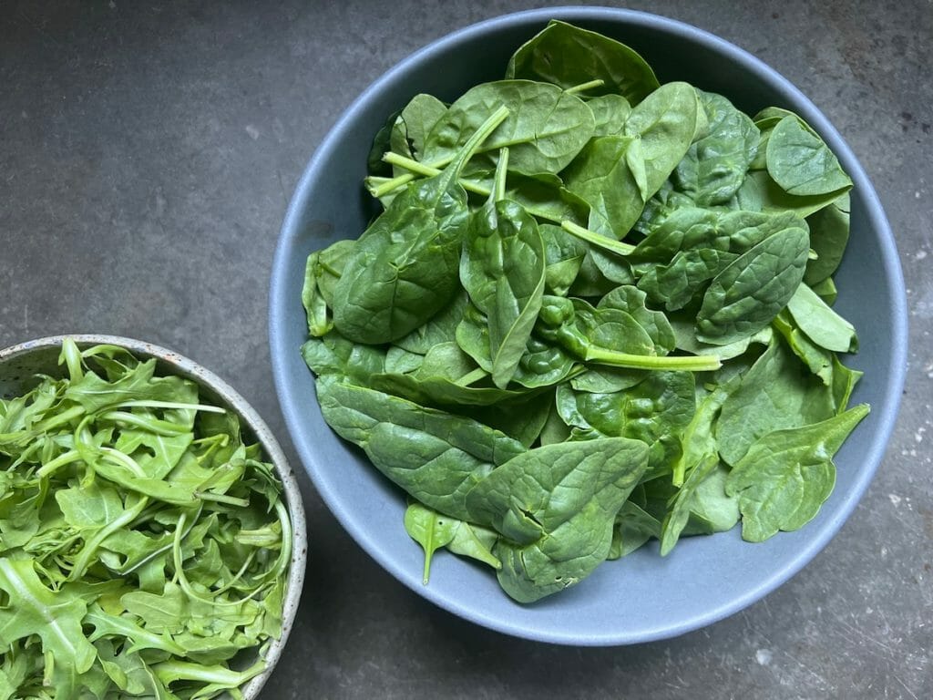 two bowls of dark leafy greens