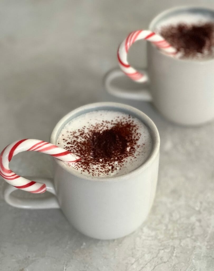 Two mugs of Mezcal Hot Chocolate with Peppermint Sticks